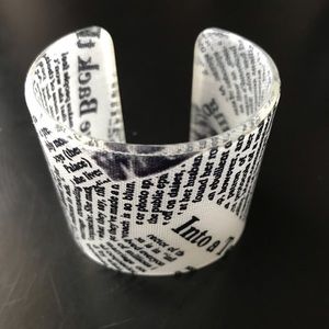 Chic lucite cuff bracelet with newsprint design.